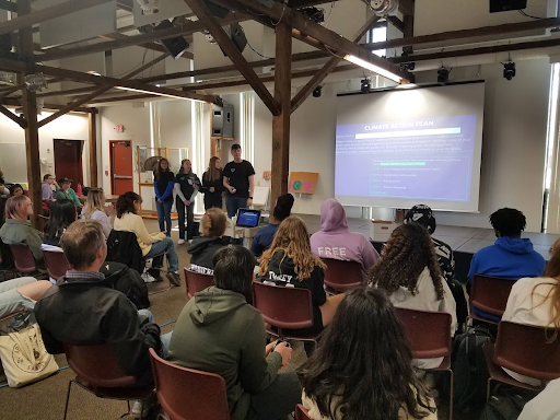 Suffield student leaders stand in front of a group of seated attendees participating in Climate Action Planning school training.
