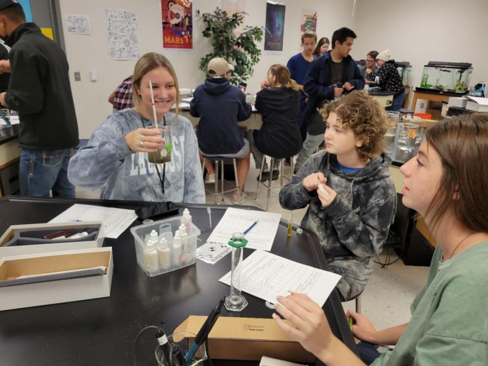 Students in science classroom with beakers and equipment testing water from local aquatic ecosystems