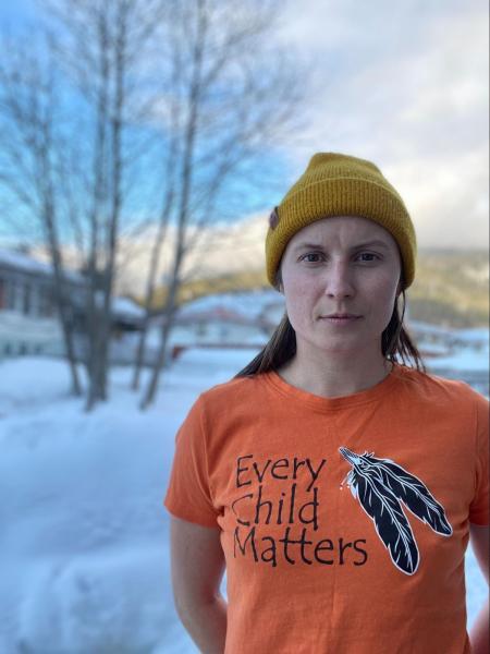 Author Jade wearing a ‘Take Me Outside’ T-shirt that supports Indigenous artists and producers and a Take Me Outside Canada made and produced merino blend Toque. Photo credit: Jade Harvey-Berrill