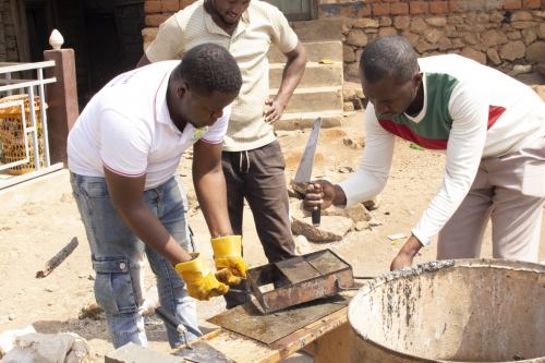 CEE-Change Fellow Fontoh Desmond Abinwi demonstrates how to create reused pavement tiles from recovered plastic.